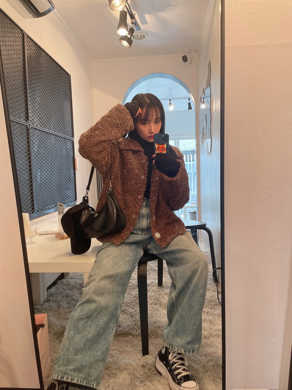 ブラウン系のダウンジャケット/コート、ブラック系のニット/セーターを着用したレディースの春コーディネートの2枚目の写真