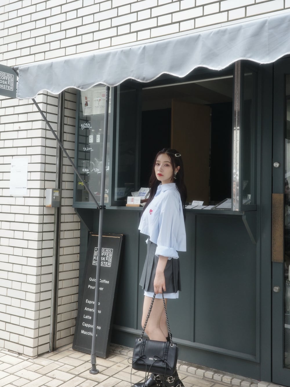 ホワイト系のシャツ/ブラウス、グレー系のスカート、ブルー系のショルダーバッグを着用したレディースの秋コーディネートの3枚目の写真