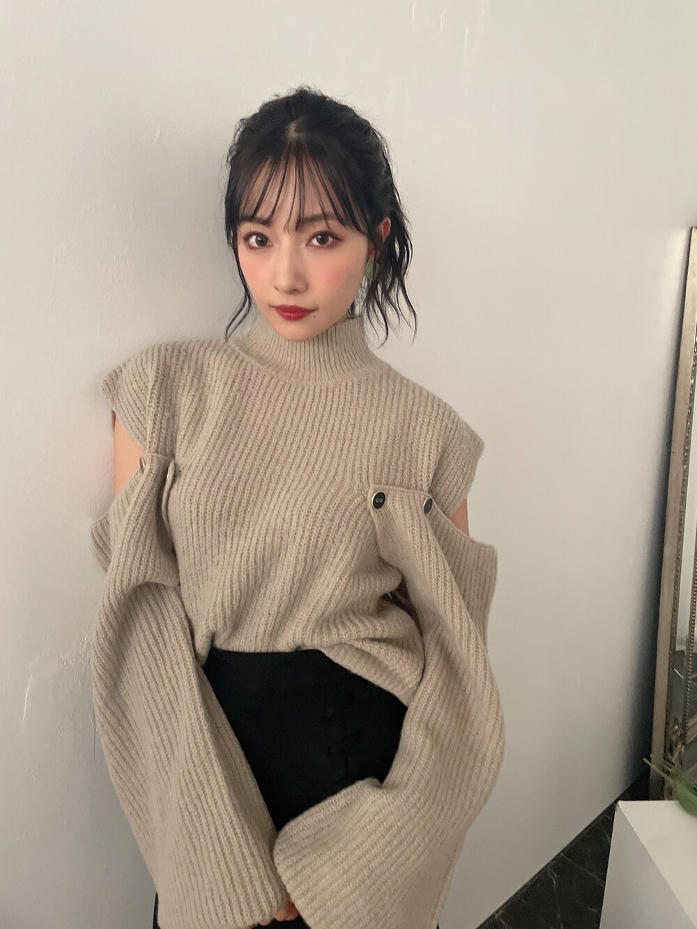 グリーン系のニット/セーター、ブラック系のスカートを着用したレディースの冬コーディネートの4枚目の写真