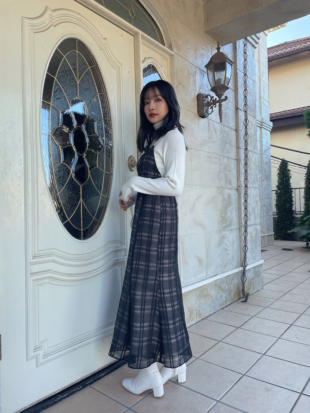 ブラック系のワンピース、ホワイト系のニット/セーターを着用したレディースの春コーディネートの2枚目の写真