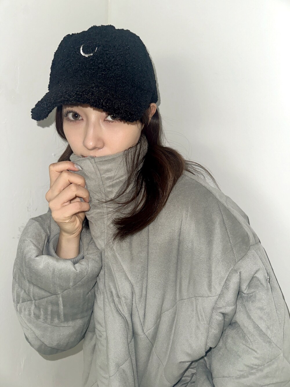 グレー系のダウンジャケット/コート、ブラック系のキャップを着用したレディースの春コーディネートの3枚目の写真