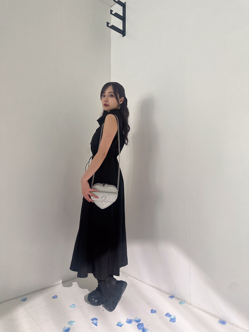 ブラック系のワンピース、シルバー系のショルダーバッグを着用したレディースの夏コーディネートの2枚目の写真