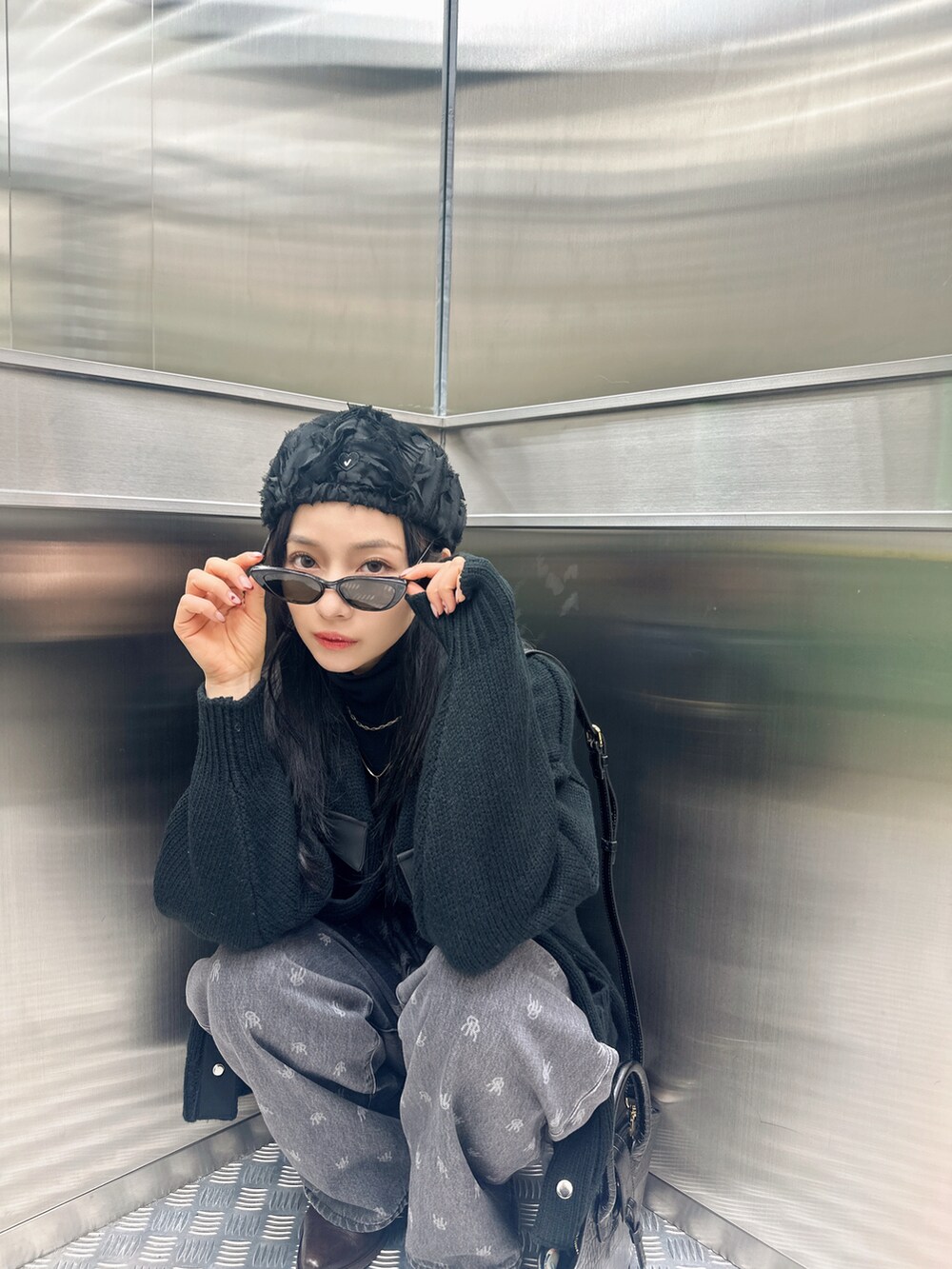 ブラック系のニット/セーターを着用したレディースの春コーディネートの3枚目の写真
