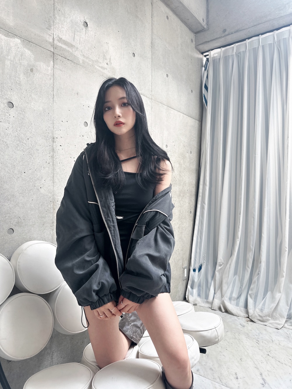 ブラック系のタンクトップ、グレー系のブルゾンを着用したレディースの秋コーディネートの2枚目の写真