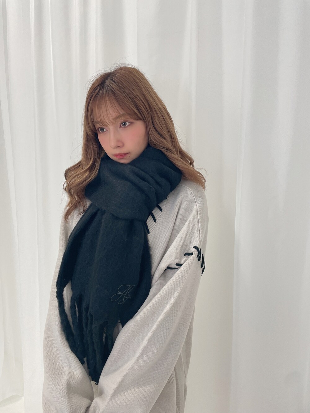 グレー系のカーディガン/ボレロ、ブラック系のマフラーを着用したレディースの冬コーディネートの3枚目の写真