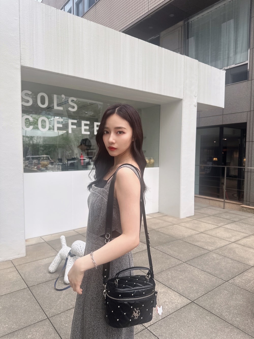 ホワイト系のショルダーバッグ、ブラック系のワンピースを着用したレディースの秋コーディネートの3枚目の写真