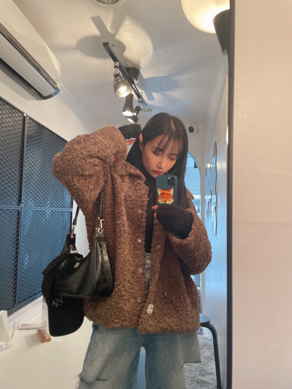 ブラウン系のダウンジャケット/コート、ブラック系のニット/セーターを着用したレディースの春コーディネートの3枚目の写真