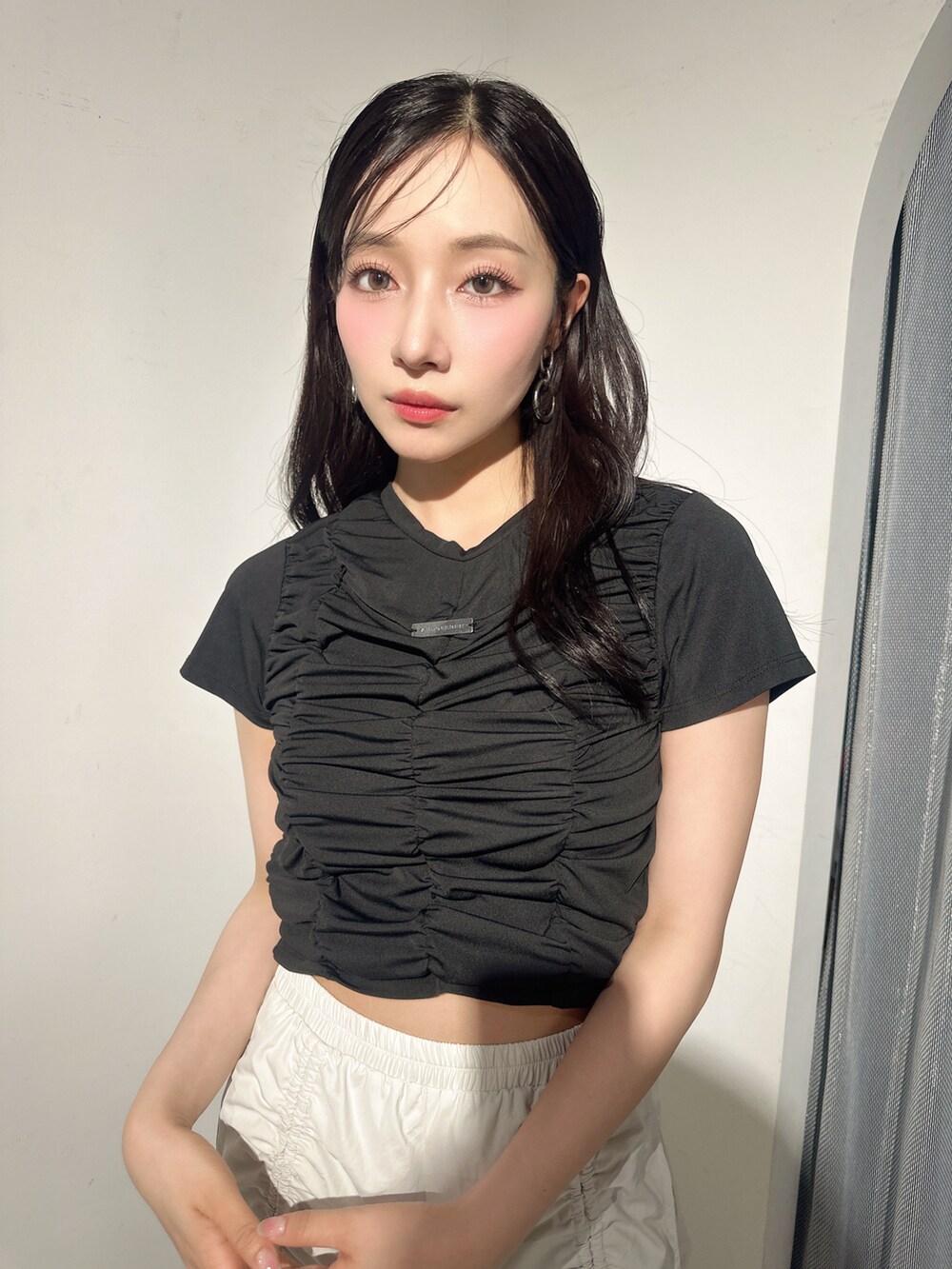 ブラック系のTシャツ/カットソー、ベージュ系のカーゴパンツを着用したレディースの夏コーディネートの2枚目の写真