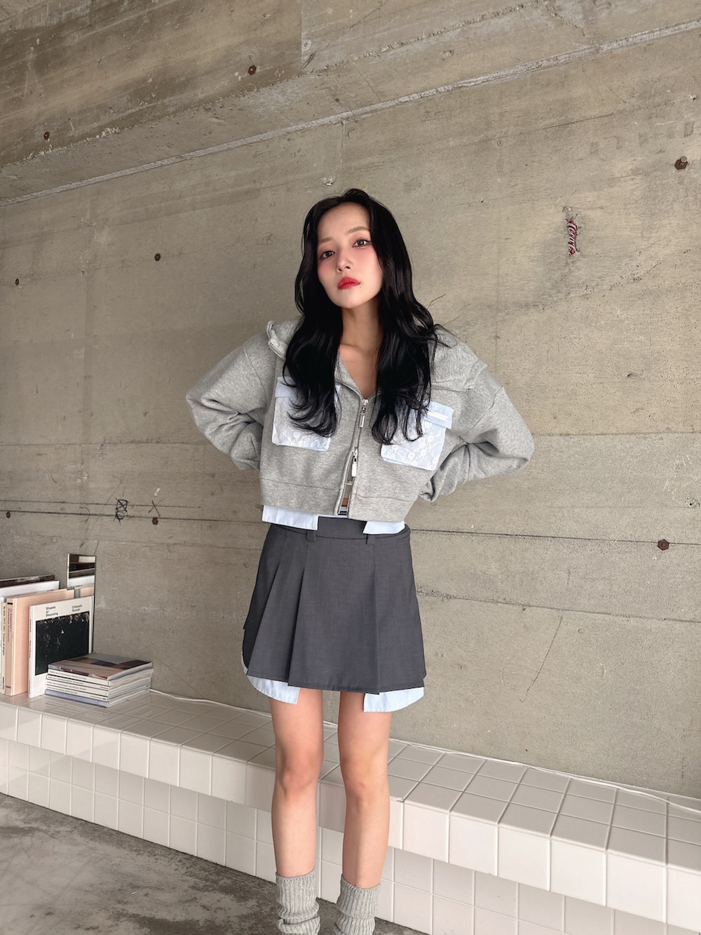 グレー系のパーカー、ブラック系のスカートを着用したレディースの春コーディネートの2枚目の写真