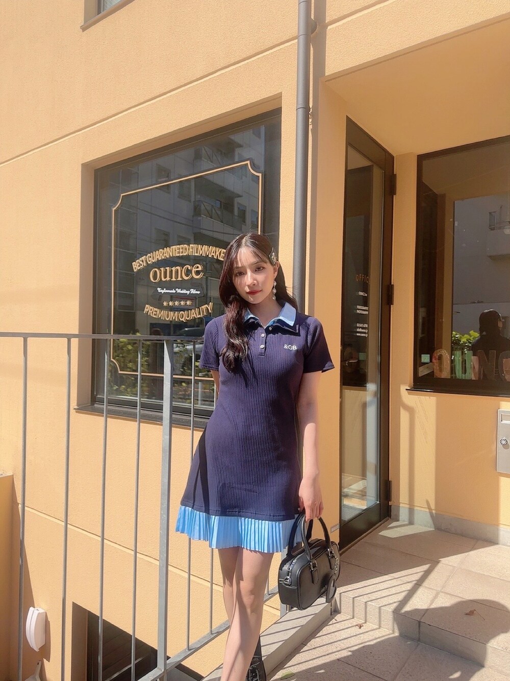 ブルー系のワンピース、ブラック系のショルダーバッグを着用したレディースの夏コーディネートの3枚目の写真