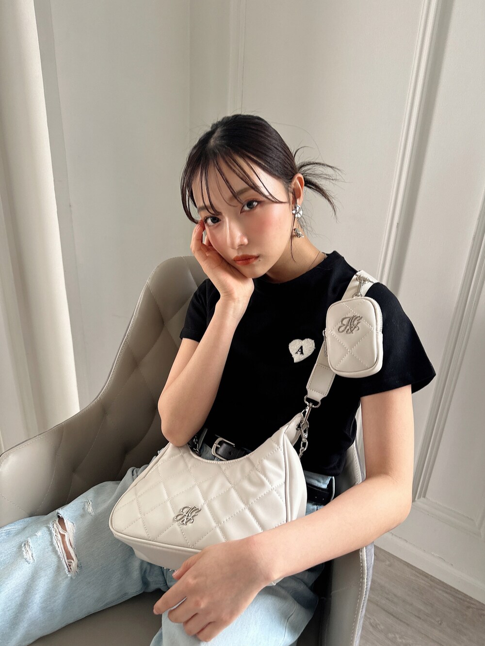 ホワイト系のショルダーバッグ、ブラック系のTシャツ/カットソーを着用したレディースの夏コーディネートの3枚目の写真