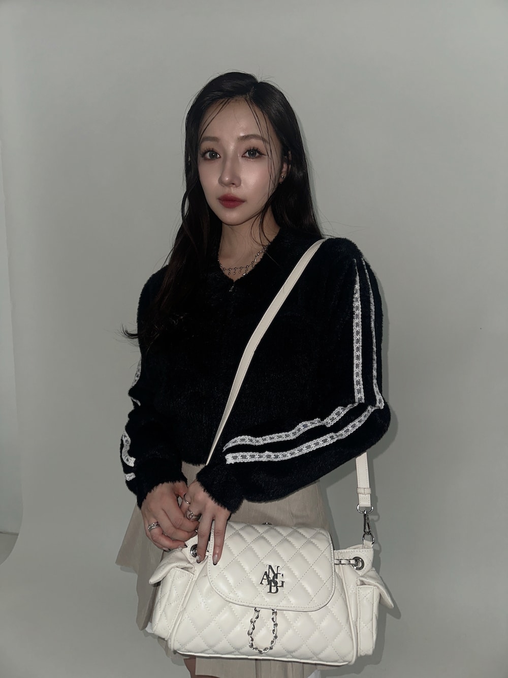 ブラック系のニット/セーター、ホワイト系のバックパック/リュックを着用したレディースの冬コーディネートの3枚目の写真