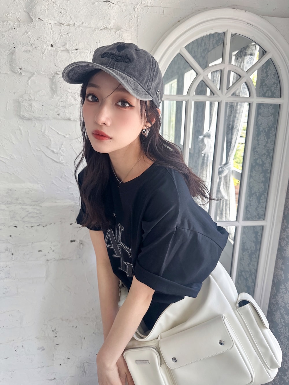 ブラック系のTシャツ/カットソー、ホワイト系のメッセンジャーバッグ、ブラック系のキャップを着用したレディースの夏コーディネートの5枚目の写真