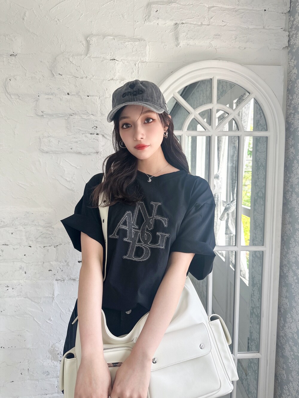 ブラック系のTシャツ/カットソー、ホワイト系のメッセンジャーバッグ、ブラック系のキャップを着用したレディースの夏コーディネートの3枚目の写真