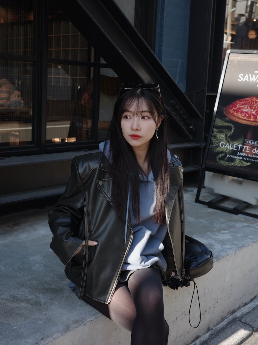 ブルー系のパーカー、ブラック系のショルダーバッグを着用したレディースの春コーディネートの4枚目の写真