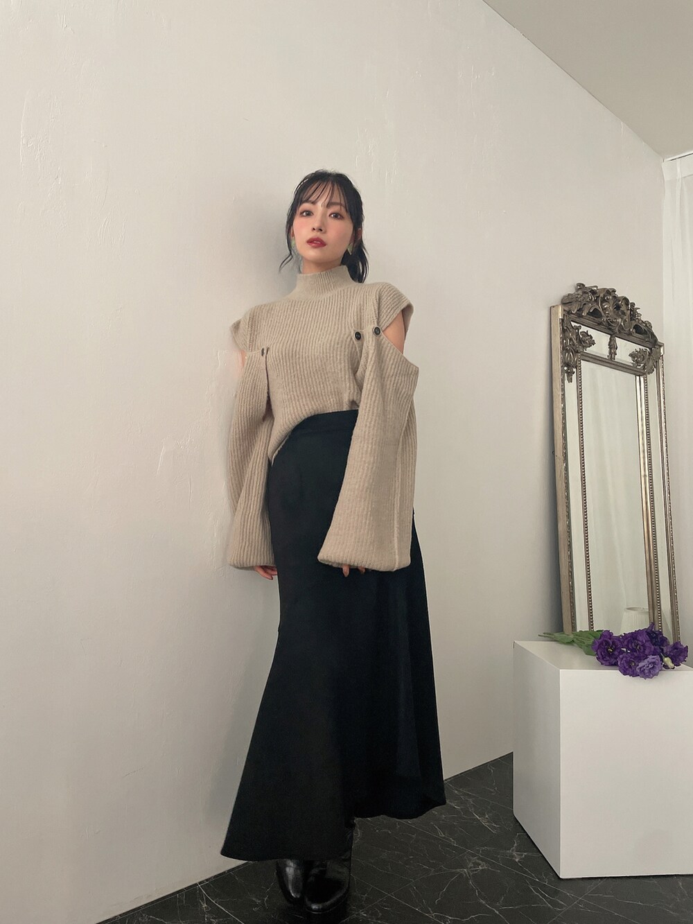 グリーン系のニット/セーター、ブラック系のスカートを着用したレディースの冬コーディネートの2枚目の写真