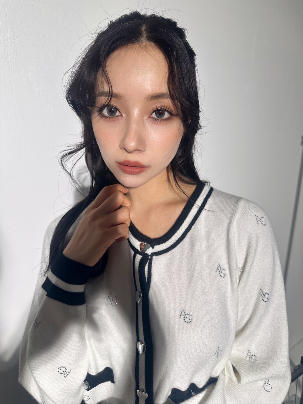 ホワイト系のアンサンブル、ブラック系のスカートを着用したレディースの冬コーディネートの5枚目の写真