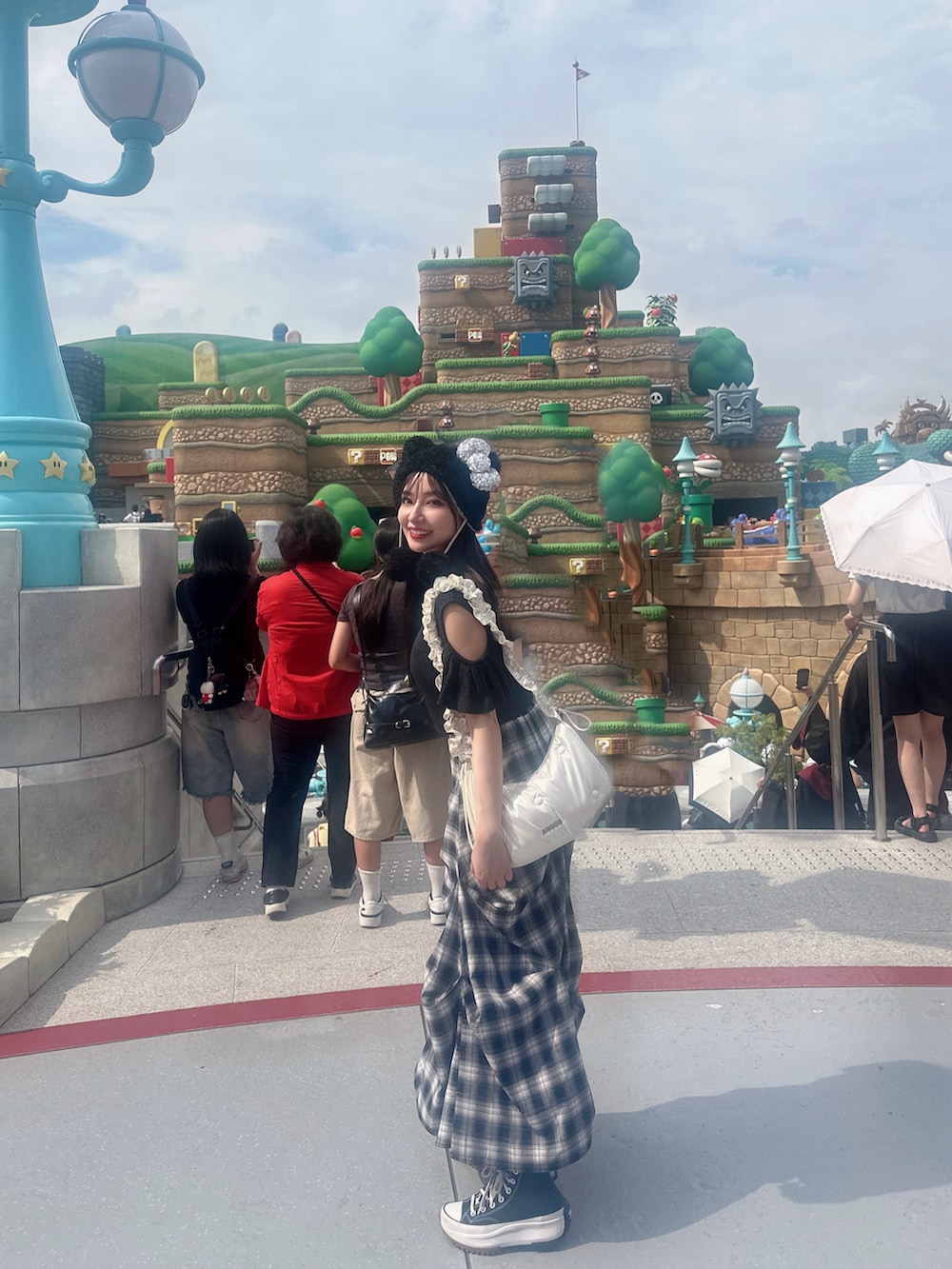 ブラック系のスカート、ホワイト系のショルダーバッグを着用したレディースの冬コーディネートの2枚目の写真