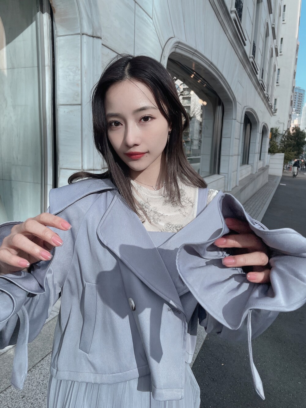 グレー系のトレンチコート、グレー系のワンピースを着用したレディースの夏コーディネートの3枚目の写真