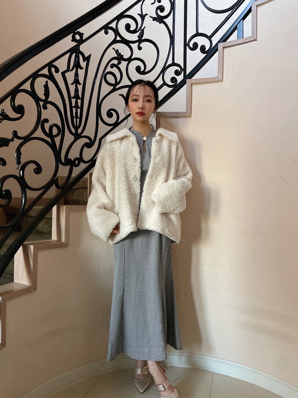 ホワイト系のダウンジャケット/コート、ブラック系のワンピースを着用したレディースの春コーディネートの2枚目の写真