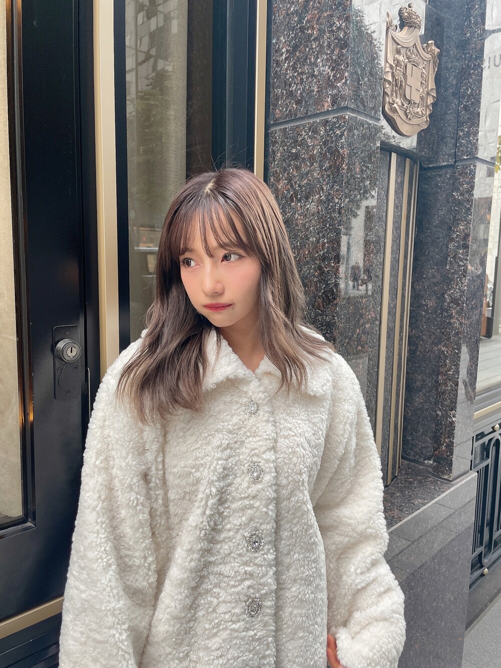 ホワイト系のダウンジャケット/コート、ベージュ系のワンピースを着用したレディースの冬コーディネートの2枚目の写真