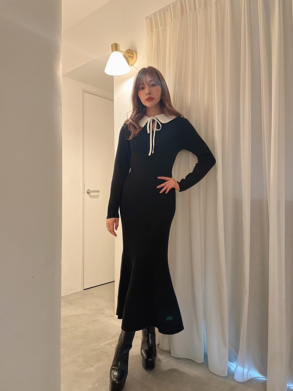 ブラック系のブーツ、ブラック系のワンピースを着用したレディースの秋コーディネートの2枚目の写真