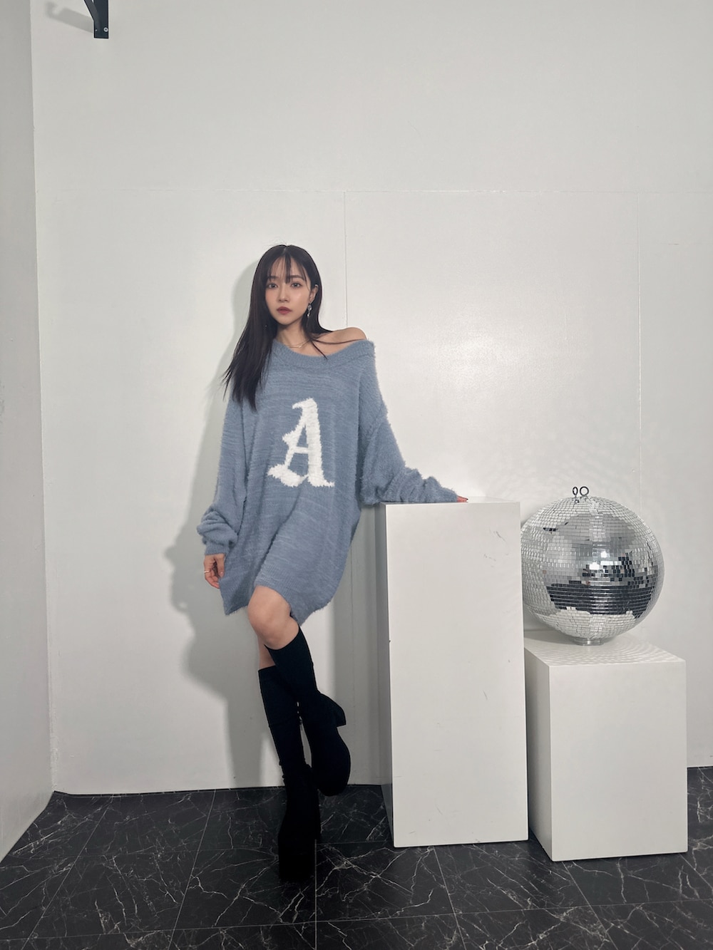 ブルー系のニット/セーターを着用したレディースの冬コーディネートの2枚目の写真