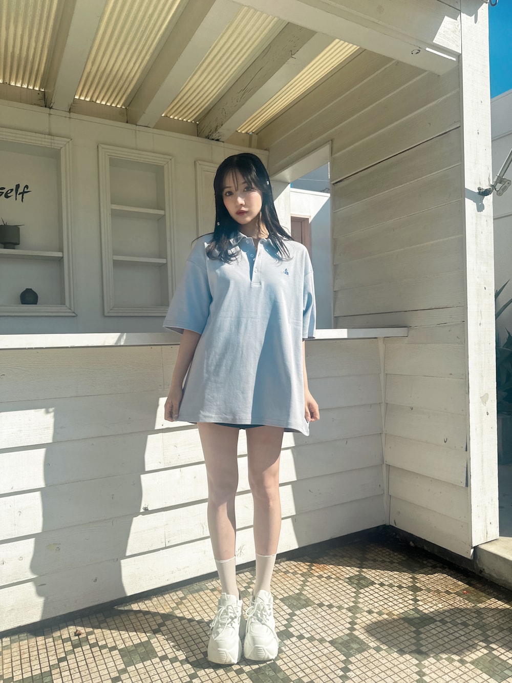 ブルー系のポロシャツを着用したレディースの春コーディネートの2枚目の写真