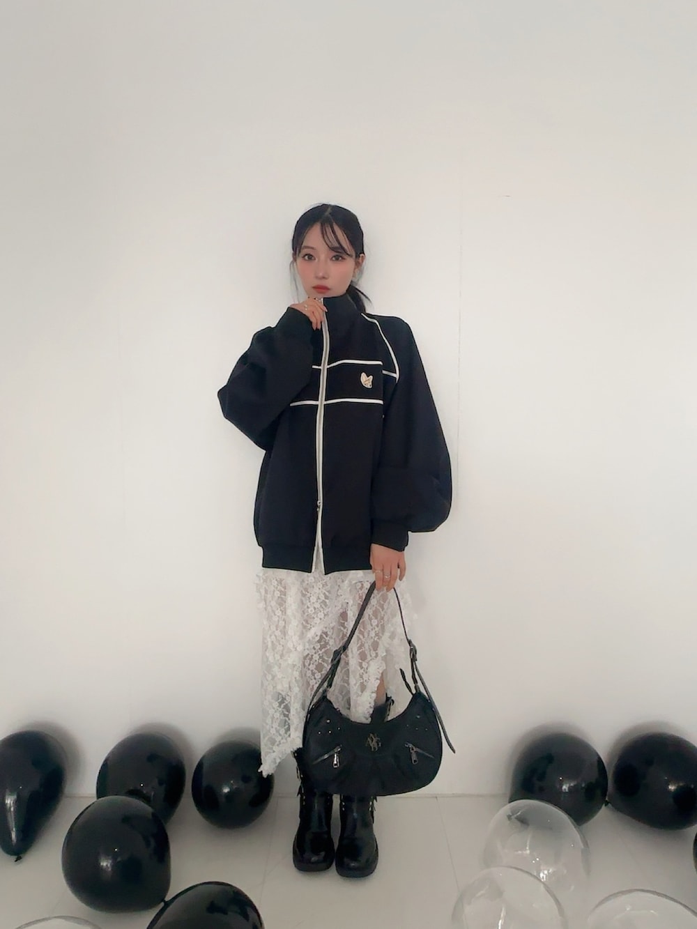 ブラック系のジャージ、ホワイト系のスカート、ブラック系のショルダーバッグを着用したレディースの夏コーディネートの2枚目の写真