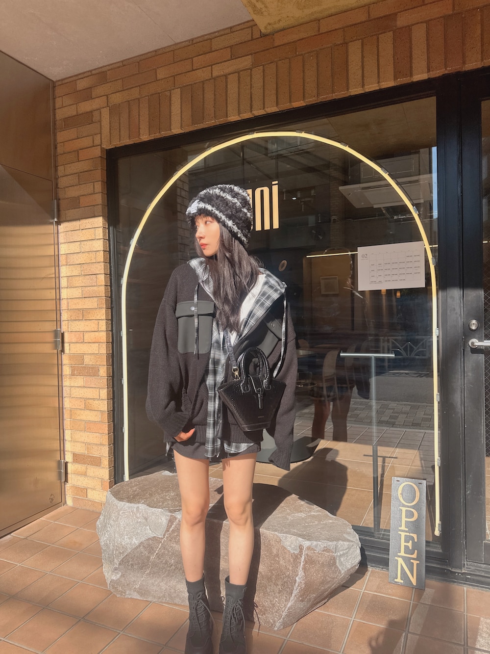 ブラック系のニット/セーター、ブラック系のシャツ/ブラウスを着用したレディースの春コーディネートの5枚目の写真