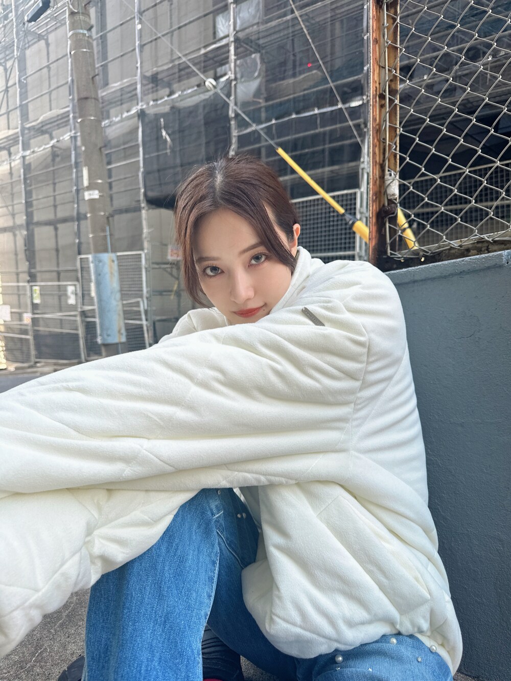 ホワイト系のダウンジャケット/コート、ブルー系のデニムパンツを着用したレディースの冬コーディネートの4枚目の写真