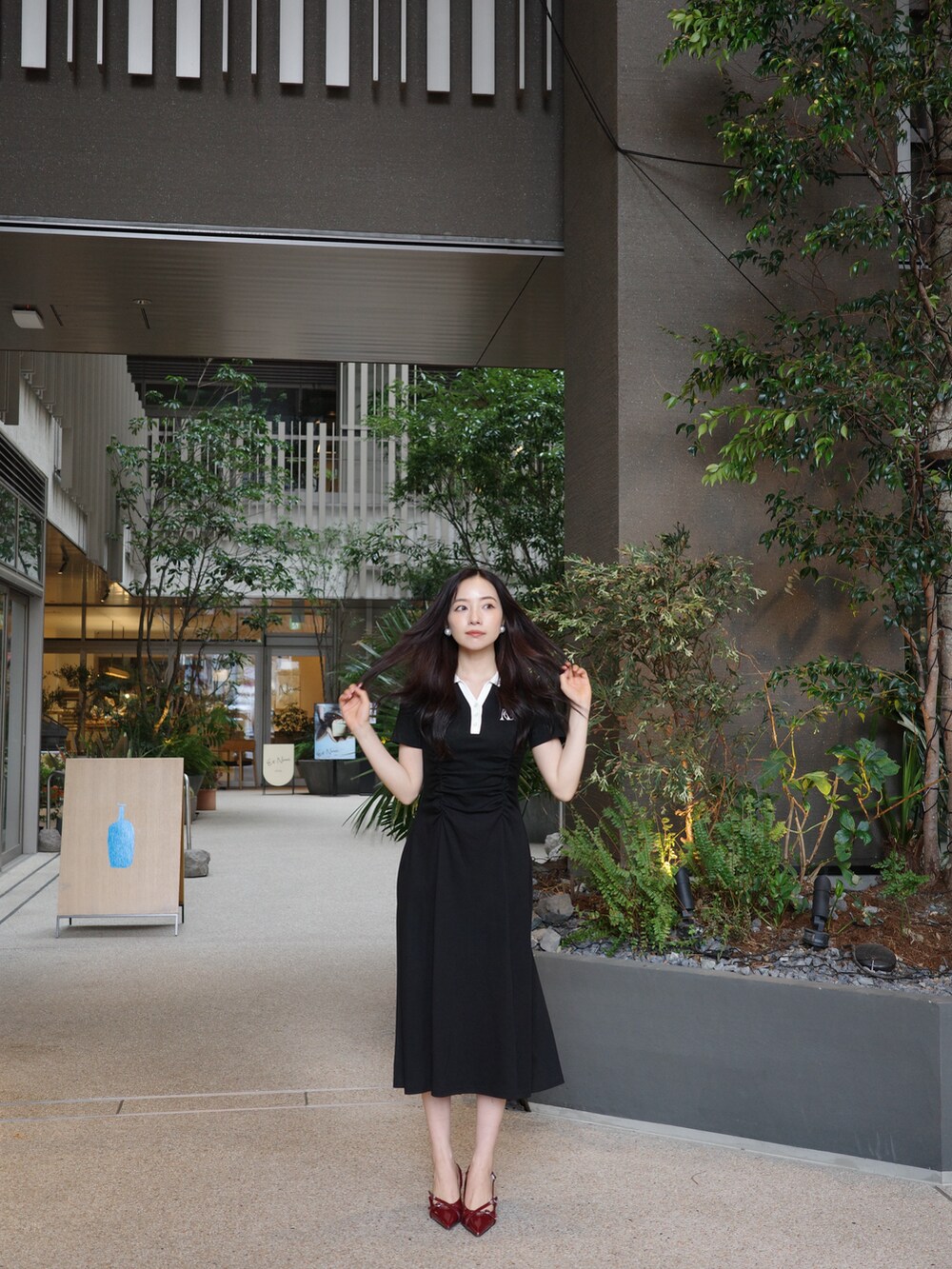 ブラック系のワンピースを着用したレディースの夏コーディネートの2枚目の写真