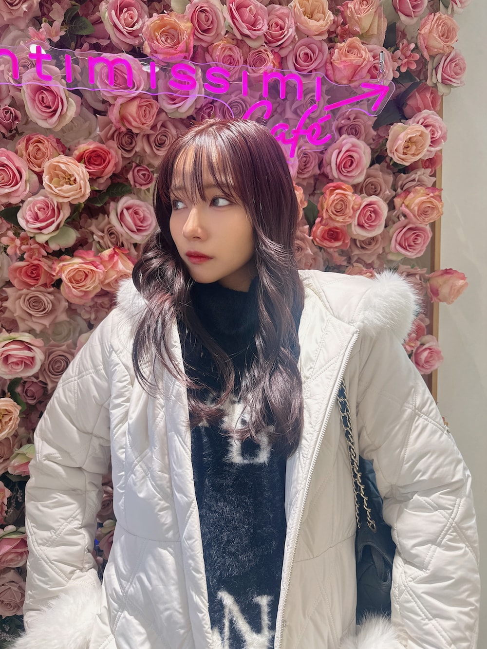 ホワイト系のダウンジャケット/コート、ブラック系のワンピース、グレー系のショルダーバッグを着用したレディースの春コーディネートの3枚目の写真