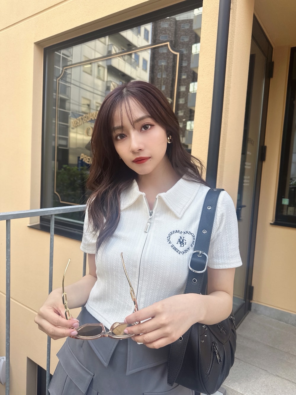 ホワイト系のその他トップス、ブラック系のショルダーバッグ、グレー系のスカートを着用したレディースの夏コーディネートの4枚目の写真