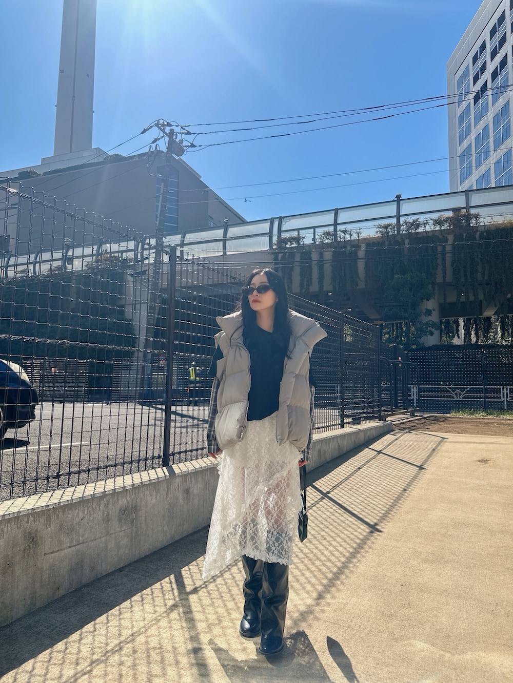 ホワイト系のスカート、ブラック系のTシャツ/カットソーを着用したレディースの夏コーディネートの2枚目の写真