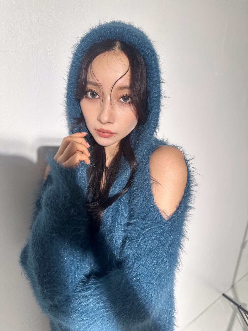 ブルー系のニット/セーターを着用したレディースの冬コーディネートの3枚目の写真