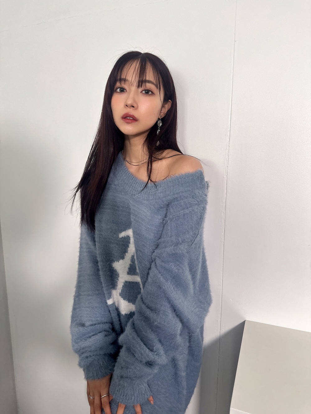 ブルー系のニット/セーターを着用したレディースの冬コーディネートの4枚目の写真