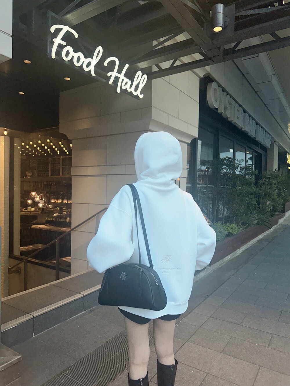 ブラック系のショルダーバッグ、ホワイト系のパーカーを着用したレディースの冬コーディネートの2枚目の写真