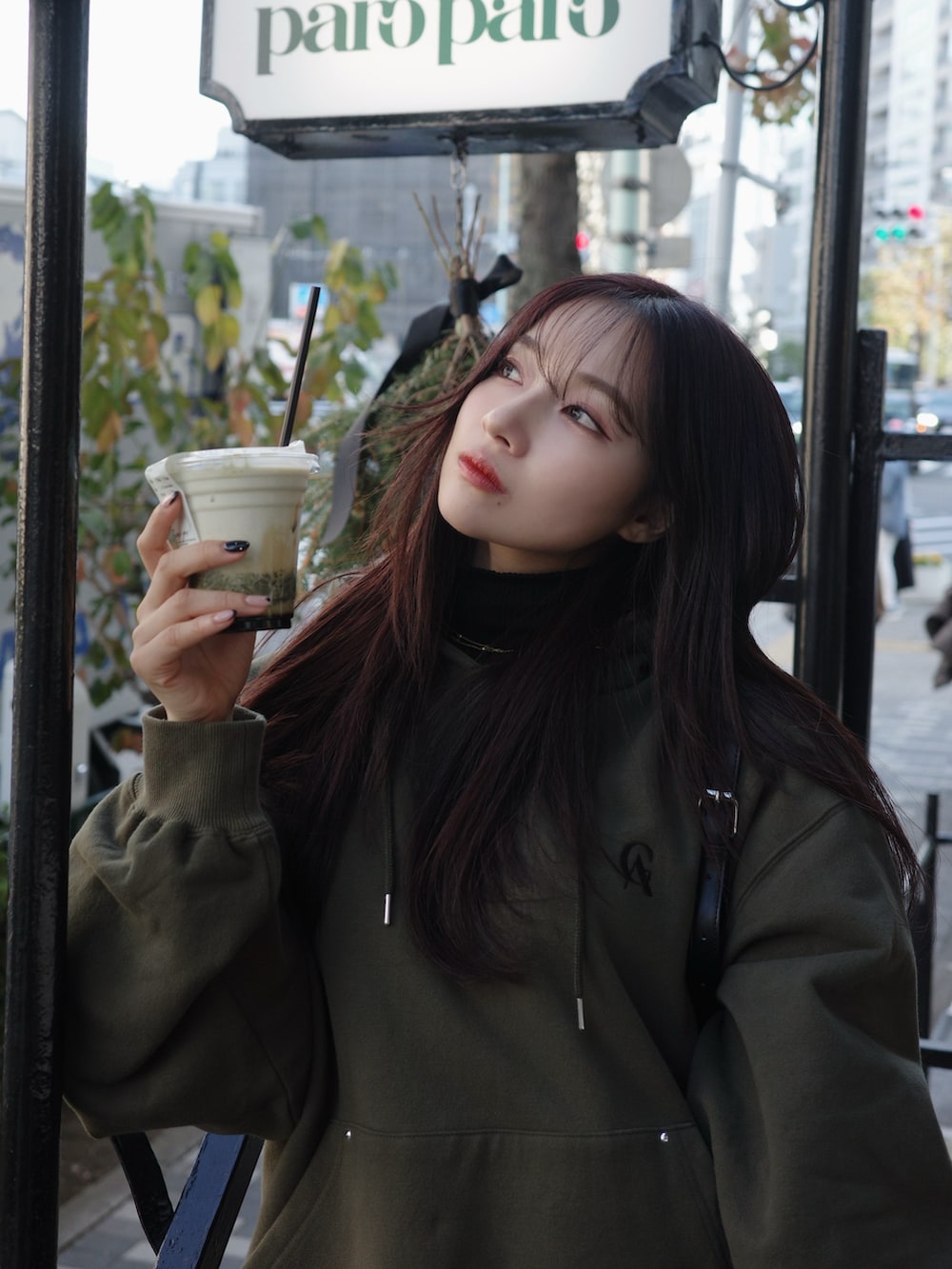 グリーン系のパーカーを着用したレディースの春コーディネートの5枚目の写真