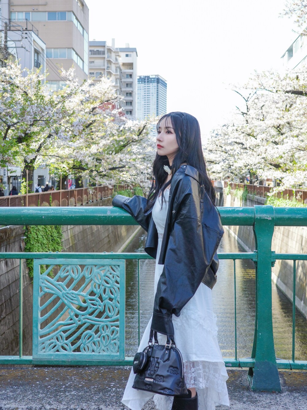 ホワイト系のワンピース、ブラック系のショルダーバッグ、ブラック系のトップスを着用したレディースの夏コーディネートの2枚目の写真