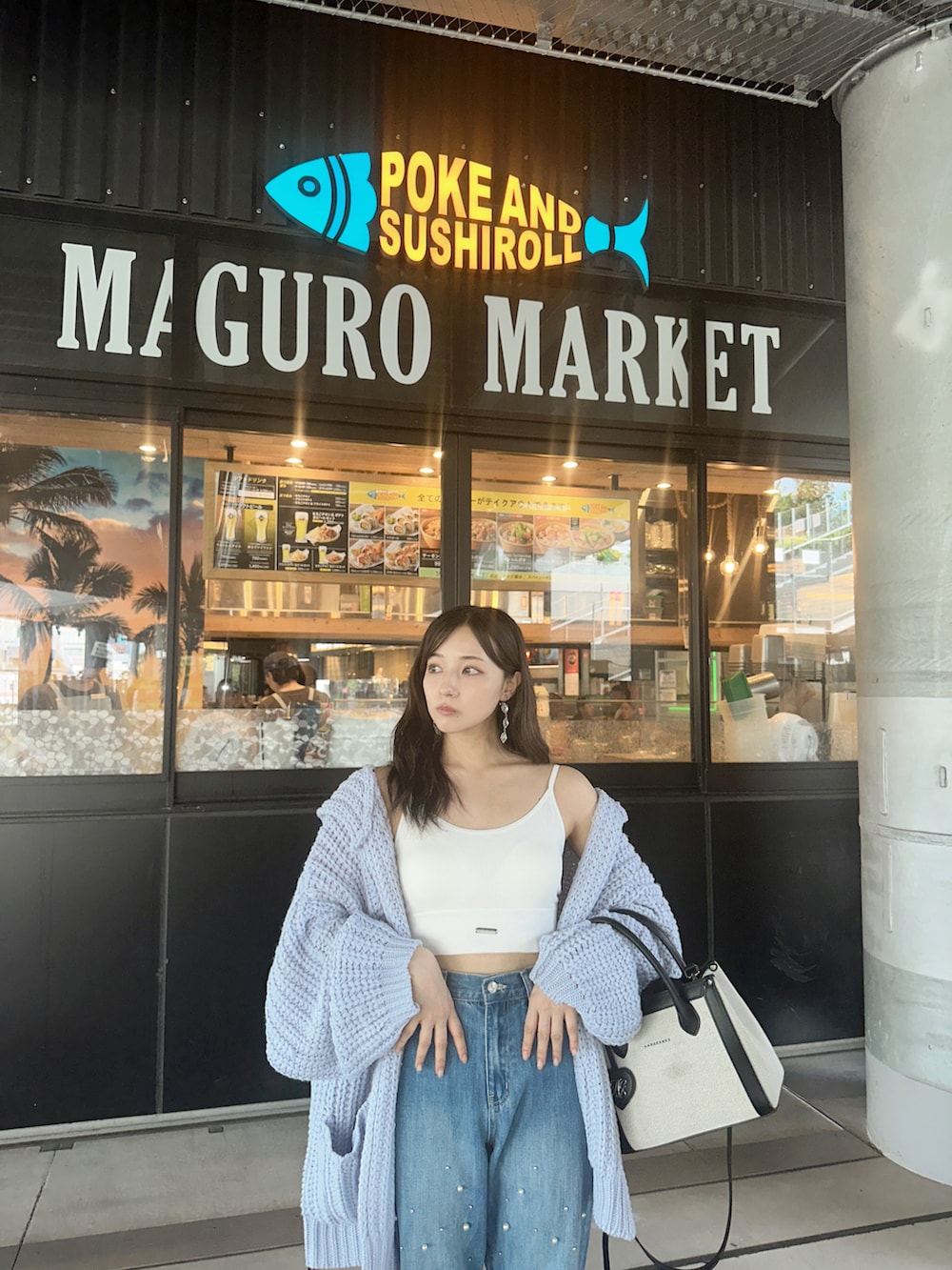 ブルー系のデニムパンツ、ブラック系のショルダーバッグを着用したレディースの冬コーディネートの2枚目の写真