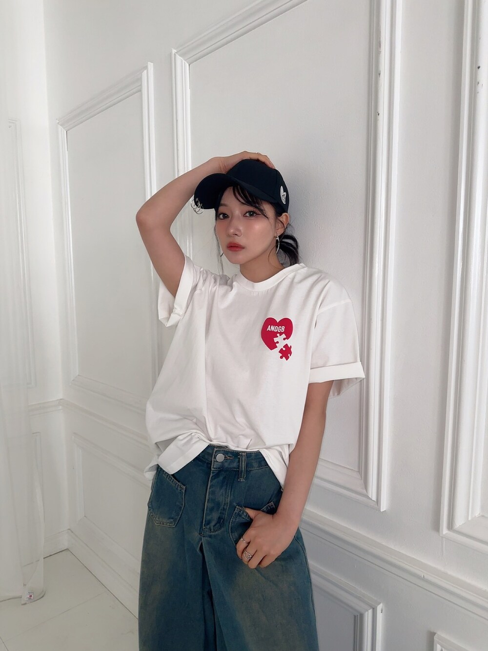 ホワイト系のTシャツ/カットソー、ブラック系のキャップを着用したレディースの夏コーディネートの3枚目の写真