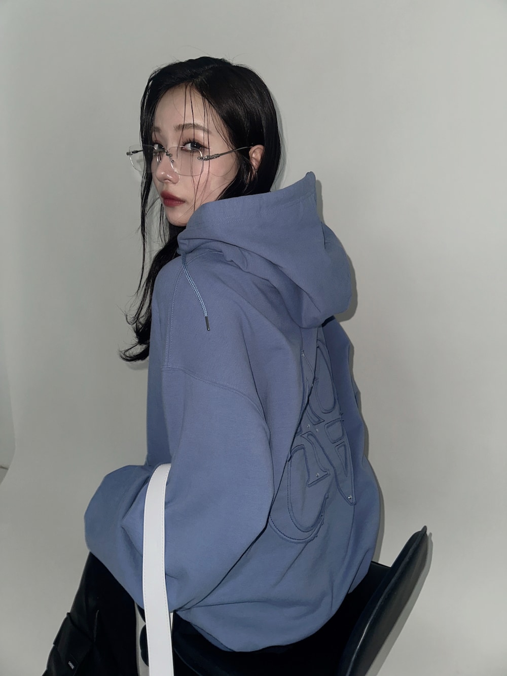 ブルー系のパーカー、グレー系のショルダーバッグを着用したレディースの冬コーディネートの3枚目の写真