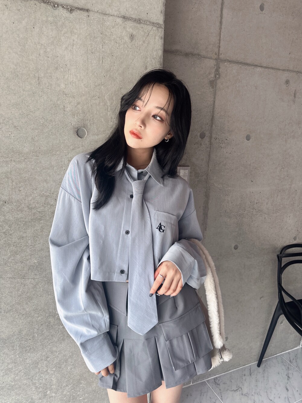 ブルー系のシャツ/ブラウス、グレー系のスカート、ホワイト系のショルダーバッグを着用したレディースの秋コーディネートの3枚目の写真