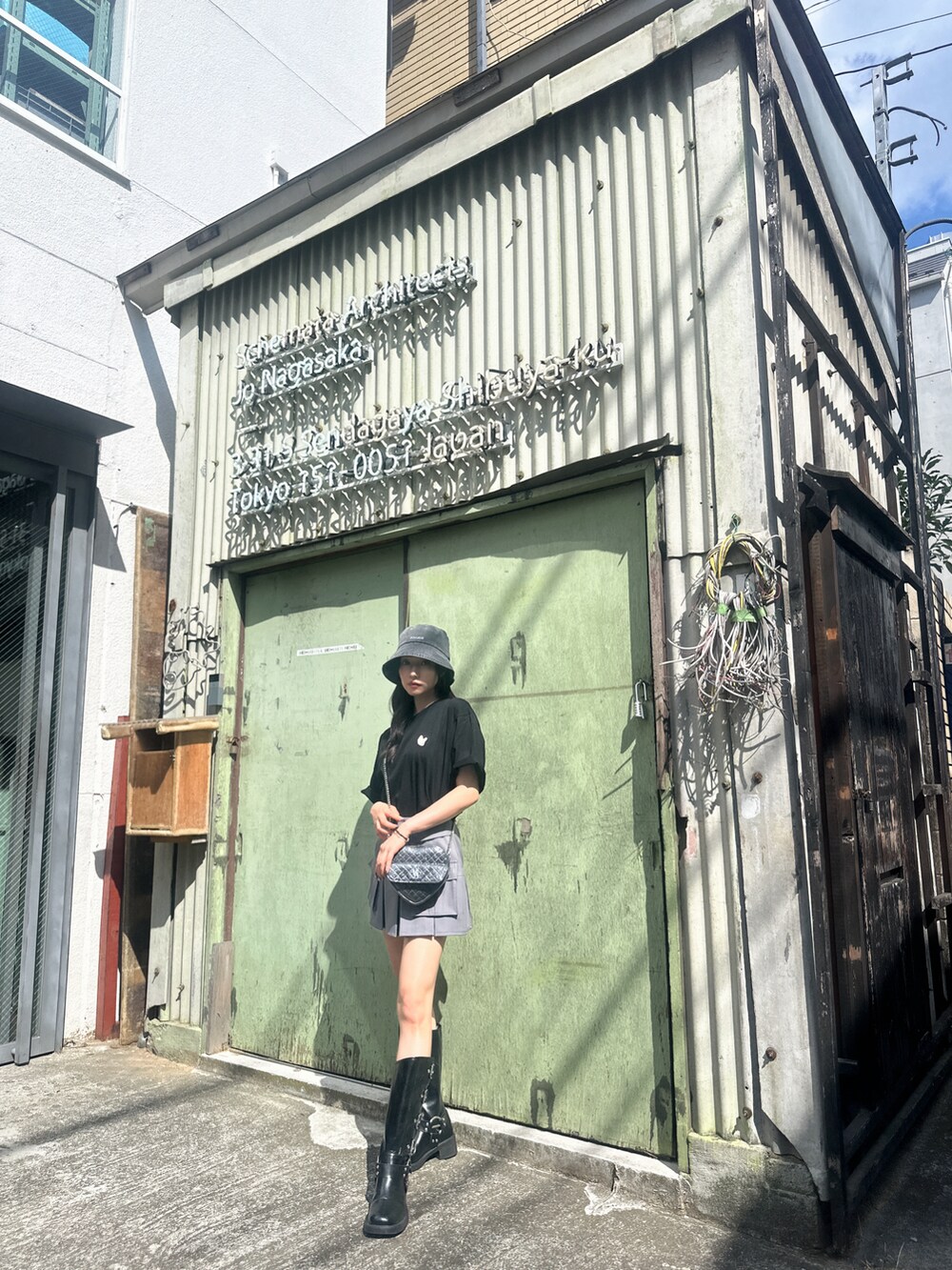 ブラック系のTシャツ/カットソー、ブラック系のショルダーバッグ、グレー系のスカートを着用したレディースの秋コーディネートの2枚目の写真