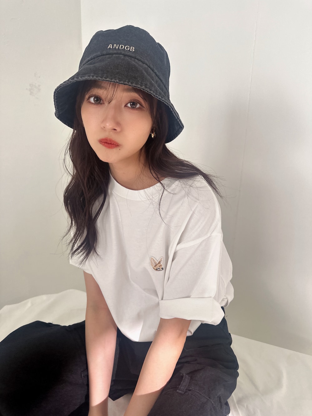 ホワイト系のTシャツ/カットソー、ブラック系のハットを着用したレディースの夏コーディネートの2枚目の写真