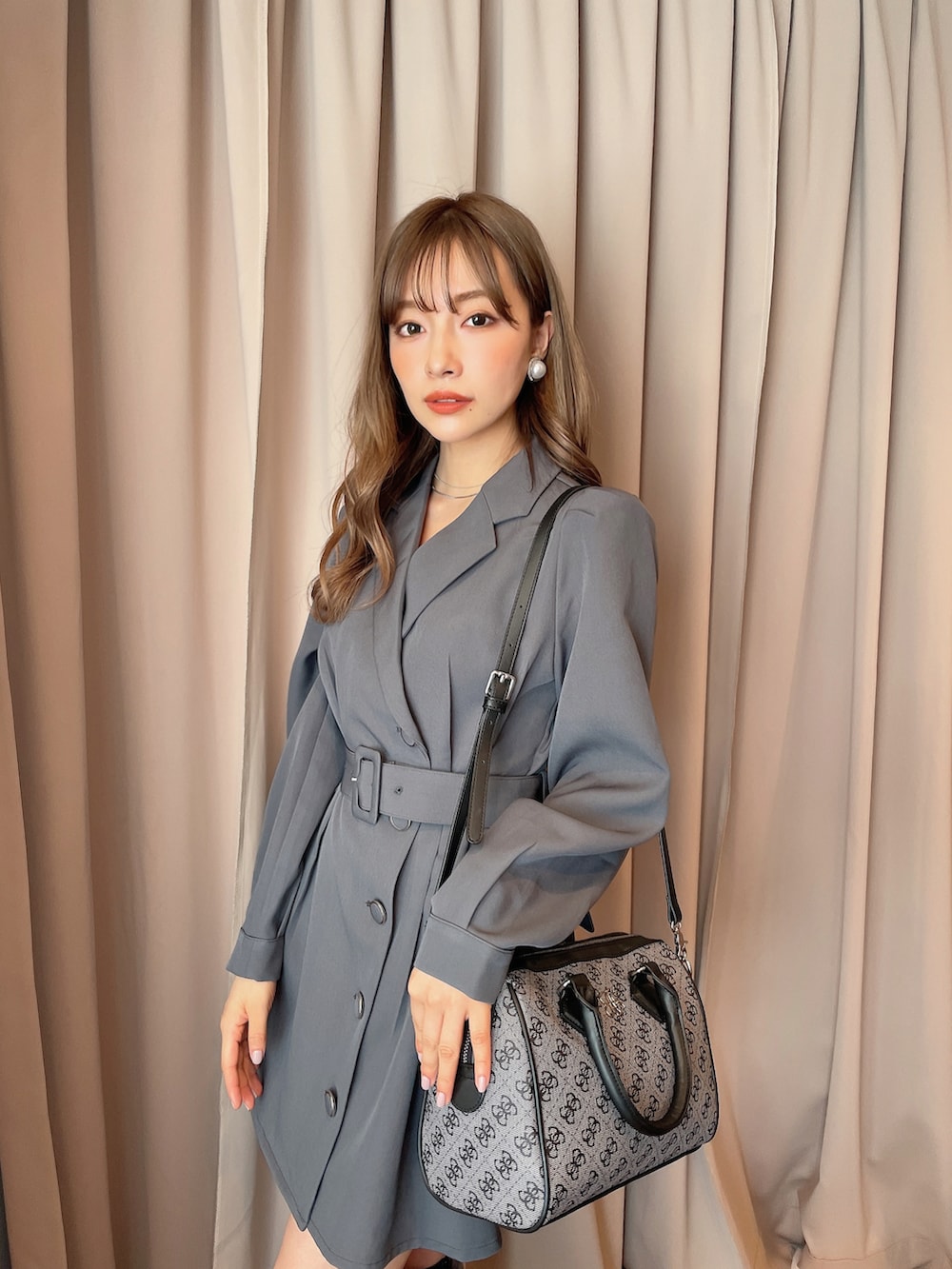 グレー系のワンピース、ブラック系のボストンバッグを着用したレディースの秋コーディネートの2枚目の写真