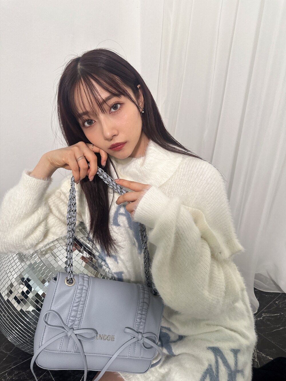 ホワイト系のワンピース、ブルー系のショルダーバッグを着用したレディースの冬コーディネートの2枚目の写真