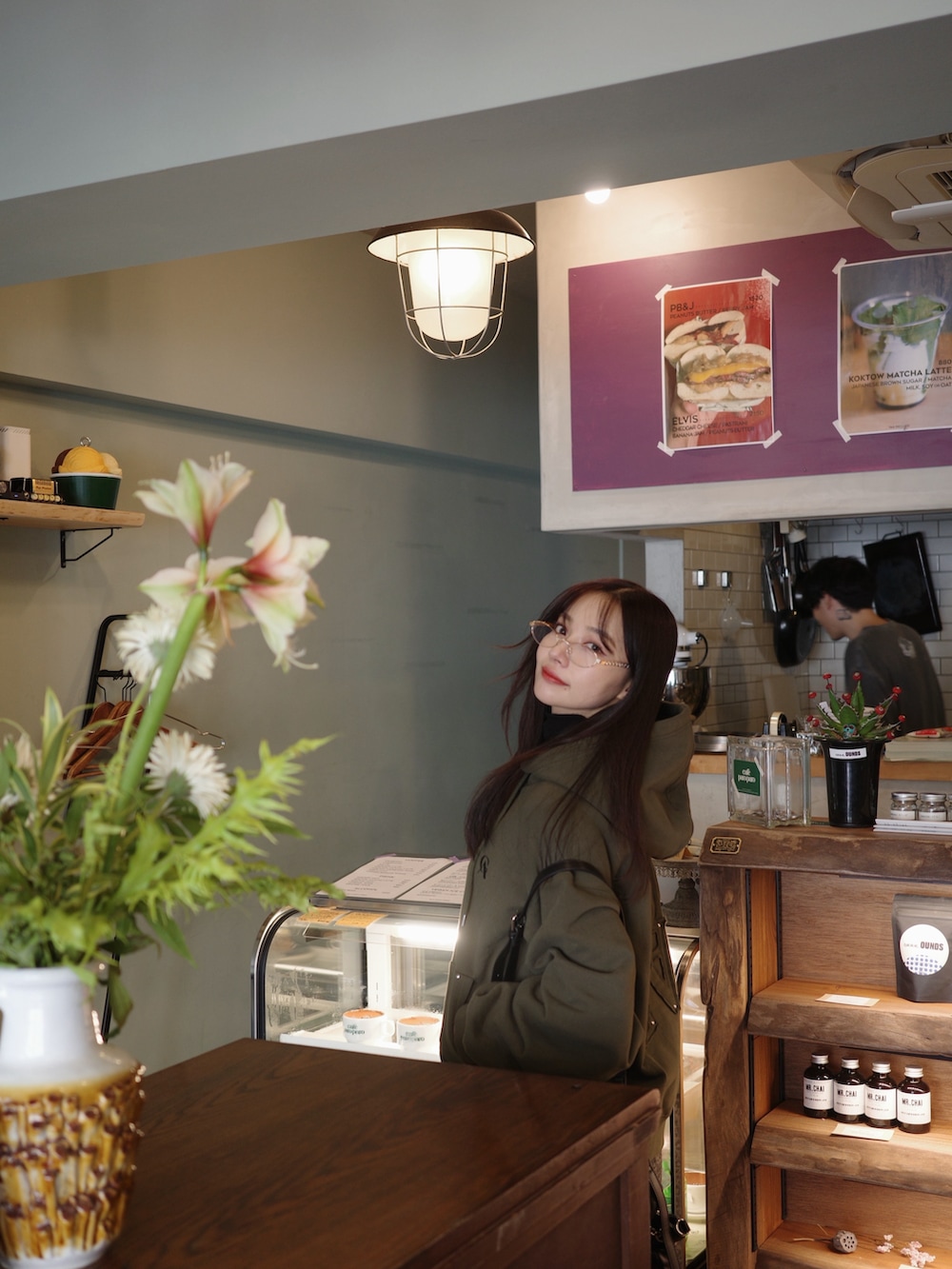 グリーン系のパーカーを着用したレディースの冬コーディネートの4枚目の写真