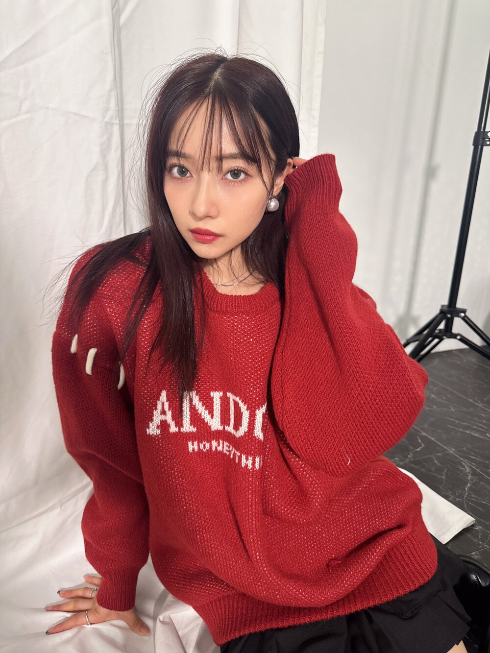 レッド系のニット/セーターを着用したレディースの冬コーディネートの2枚目の写真